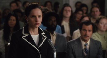 Movie still from “On the Basis of Sex” (2018), directed by Mimi Leder – A woman standing in front of a crowd of people; Close Up shot, Over the shoulder angle