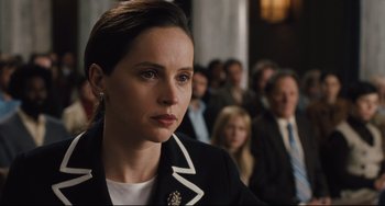 Movie still from “On the Basis of Sex” (2018), directed by Mimi Leder – A woman in black jacket looking at the camera; Close Up shot, Over the shoulder angle