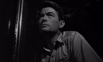 Movie still from “On the Beach” (1959), directed by Stanley Kramer – A man looking up into the air while standing next to a wall; Close Up shot, Low angle