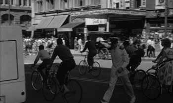 Movie still from “On the Beach” (1959), directed by Stanley Kramer – A black and white photo of people on bicycles; Extreme Wide shot, High angle