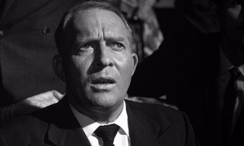 Movie still from “On the Beach” (1959), directed by Stanley Kramer – An older man wearing a suit and tie; Close Up shot, Low angle