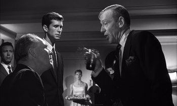 Movie still from “On the Beach” (1959), directed by Stanley Kramer – A man and a woman are talking to each other in a room; Medium shot, Over the shoulder angle