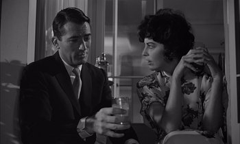 Movie still from “On the Beach” (1959), directed by Stanley Kramer – A man and a woman sitting at a dinner table; Medium shot, Over the shoulder angle
