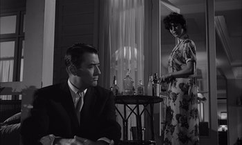 Movie still from “On the Beach” (1959), directed by Stanley Kramer – A man and a woman are standing in front of a bar; Medium shot, Low angle