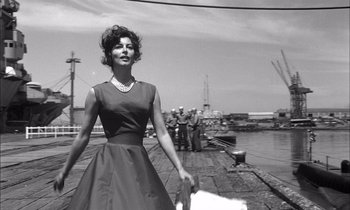 Movie still from “On the Beach” (1959), directed by Stanley Kramer – An old photo of a woman walking on a pier; Medium shot, Low angle