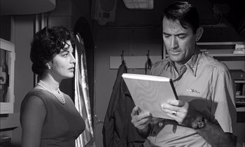 Movie still from “On the Beach” (1959), directed by Stanley Kramer – A man and a woman looking at a piece of paper; Medium shot, Over the shoulder angle