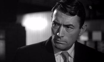 Movie still from “On the Beach” (1959), directed by Stanley Kramer – Black and white photograph of a man wearing a suit and tie; Close Up shot, Low angle
