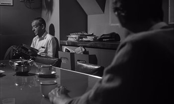 Movie still from “On the Beach” (1959), directed by Stanley Kramer – Two men sitting at a table in front of each other; Medium shot, Over the shoulder angle