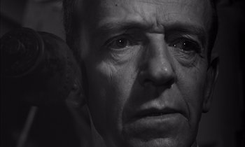 Movie still from “On the Beach” (1959), directed by Stanley Kramer – An older man with a sad look on his face; Close Up shot, Over the shoulder angle