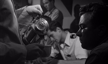 Movie still from “On the Beach” (1959), directed by Stanley Kramer – A man pouring something into a cup in front of another man; Medium shot, Low angle