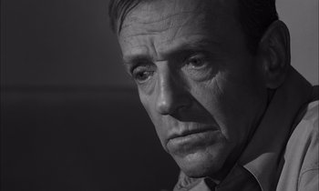 Movie still from “On the Beach” (1959), directed by Stanley Kramer – Black and white photograph of a man looking sad; Close Up shot, Over the shoulder angle