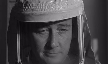 Movie still from “On the Beach” (1959), directed by Stanley Kramer – A person wearing a protective helmet and a face shield; Close Up shot, Low angle