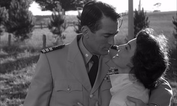 Movie still from “On the Beach” (1959), directed by Stanley Kramer – A man and a little girl kissing each other in uniform; Medium shot, Low angle