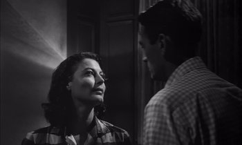 Movie still from “On the Beach” (1959), directed by Stanley Kramer – A man and a woman standing next to each other in a room; Close Up shot, Low angle