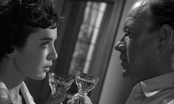Movie still from “On the Beach” (1959), directed by Stanley Kramer – A man and a woman holding wine glasses in front of each other; Close Up shot, Over the shoulder angle