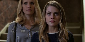 Movie still from “13 Reasons Why” (2017), created by Brian Yorkey – A woman standing next to another woman in front of a wall; Close Up shot, Over the shoulder angle