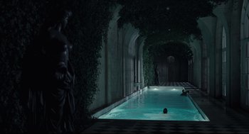 Movie still from “On the Rocks” (2020), directed by Sofia Coppola – A man swimming in a pool at night time; Extreme Wide shot, High angle