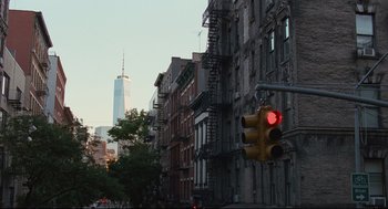 Movie still from “On the Rocks” (2020), directed by Sofia Coppola – A red traffic light hanging from the side of a building; Extreme Wide shot, Low angle