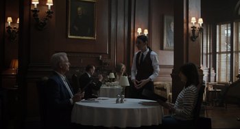 Movie still from “On the Rocks” (2020), directed by Sofia Coppola – A group of people sitting around a table in a room; Wide shot, Over the shoulder angle