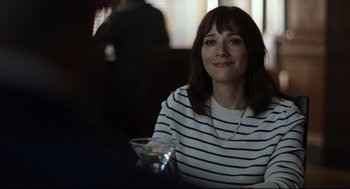 Movie still from “On the Rocks” (2020), directed by Sofia Coppola – A woman sitting at a table holding a glass; Close Up shot, Over the shoulder angle