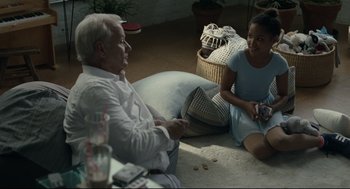 Movie still from “On the Rocks” (2020), directed by Sofia Coppola – A man and a woman sitting on the floor; Medium shot, Over the shoulder angle