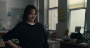 Movie still from “On the Rocks” (2020), directed by Sofia Coppola – A woman smiling while standing in a room; Medium shot, Over the shoulder angle