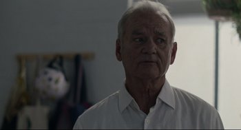 Movie still from “On the Rocks” (2020), directed by Sofia Coppola – An older man wearing a white shirt looking at the camera; Close Up shot, Low angle