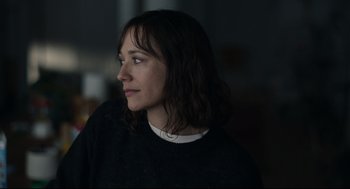 Movie still from “On the Rocks” (2020), directed by Sofia Coppola – A woman in a black sweater looking to her left; Close Up shot, Over the shoulder angle