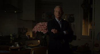 Movie still from “On the Rocks” (2020), directed by Sofia Coppola – An older man standing in front of a vase filled with roses; Medium shot, Over the shoulder angle