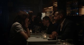 Movie still from “On the Rocks” (2020), directed by Sofia Coppola – A group of people sitting around a table at a restaurant; Medium shot, Over the shoulder angle