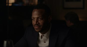 Movie still from “On the Rocks” (2020), directed by Sofia Coppola – A man wearing a suit and tie sitting in front of a window; Close Up shot, Over the shoulder angle