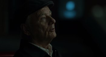 Movie still from “On the Rocks” (2020), directed by Sofia Coppola – An old man wearing a hat looking up at the sky; Close Up shot, Over the shoulder angle