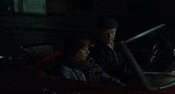Movie still from “On the Rocks” (2020), directed by Sofia Coppola – A man and a woman sitting in a red car; Medium shot, High angle