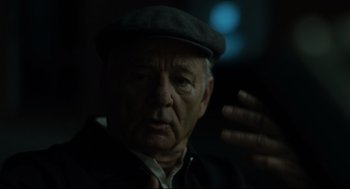 Movie still from “On the Rocks” (2020), directed by Sofia Coppola – An older man wearing a hat and a jacket; Close Up shot, Over the shoulder angle