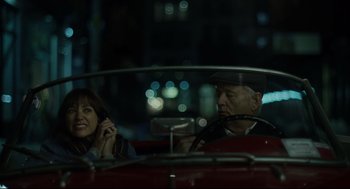 Movie still from “On the Rocks” (2020), directed by Sofia Coppola – An older man and a young woman sitting in a red car; Medium shot, Over the shoulder angle