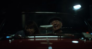 Movie still from “On the Rocks” (2020), directed by Sofia Coppola – An older man and a younger woman in a red car; Medium shot, Low angle