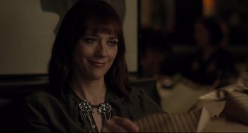 Movie still from “On the Rocks” (2020), directed by Sofia Coppola – A woman sitting in front of a guitar smiling for the camera; Close Up shot, Over the shoulder angle