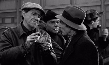 Movie still from “On the Waterfront” (1954), directed by Elia Kazan – A group of men standing next to each other; Medium shot, Over the shoulder angle