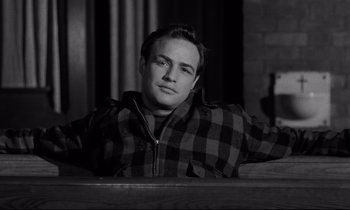 Movie still from “On the Waterfront” (1954), directed by Elia Kazan – Black and white photograph of a man in a plaid shirt; Close Up shot, Low angle