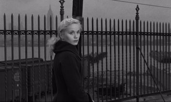 Movie still from “On the Waterfront” (1954), directed by Elia Kazan – Black and white photograph of a woman in front of a fence; Medium shot, High angle