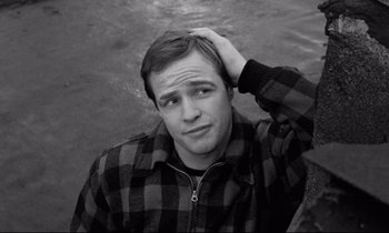 Movie still from “On the Waterfront” (1954), directed by Elia Kazan – Black and white photograph of a man in a plaid shirt; Close Up shot, High angle