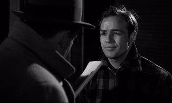Movie still from “On the Waterfront” (1954), directed by Elia Kazan – A black and white photo of a man looking at another man; Close Up shot, Over the shoulder angle