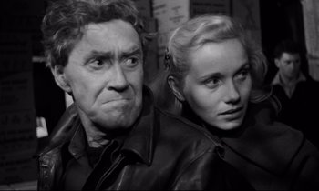 Movie still from “On the Waterfront” (1954), directed by Elia Kazan – An older man and a younger woman looking at the camera; Close Up shot, High angle