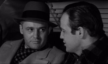Movie still from “On the Waterfront” (1954), directed by Elia Kazan – A man in a hat talking to another man in a hat; Close Up shot, Over the shoulder angle