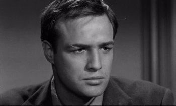 Movie still from “On the Waterfront” (1954), directed by Elia Kazan – A black - and - white photo of a man in a jacket; Close Up shot, Low angle