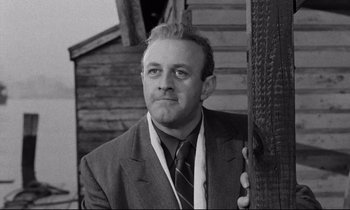 Movie still from “On the Waterfront” (1954), directed by Elia Kazan – Black and white photograph of a man wearing a suit and tie; Close Up shot, Low angle