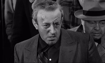 Movie still from “On the Waterfront” (1954), directed by Elia Kazan – A black and white photo of a man with a bandage on his head; Close Up shot, High angle
