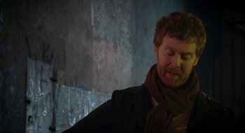 Movie still from “Once” (2007), directed by John Carney – A man in a scarf and a black jacket; Medium shot, Over the shoulder angle