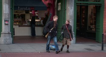 Movie still from “Once” (2007), directed by John Carney – A man and a woman walking down a street; Wide shot, Over the shoulder angle