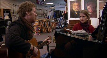 Movie still from “Once” (2007), directed by John Carney – A man and a woman are playing a guitar and a piano; Medium shot, Over the shoulder angle